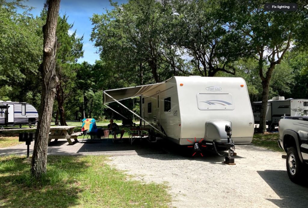 RV parked in a wooded campsite.