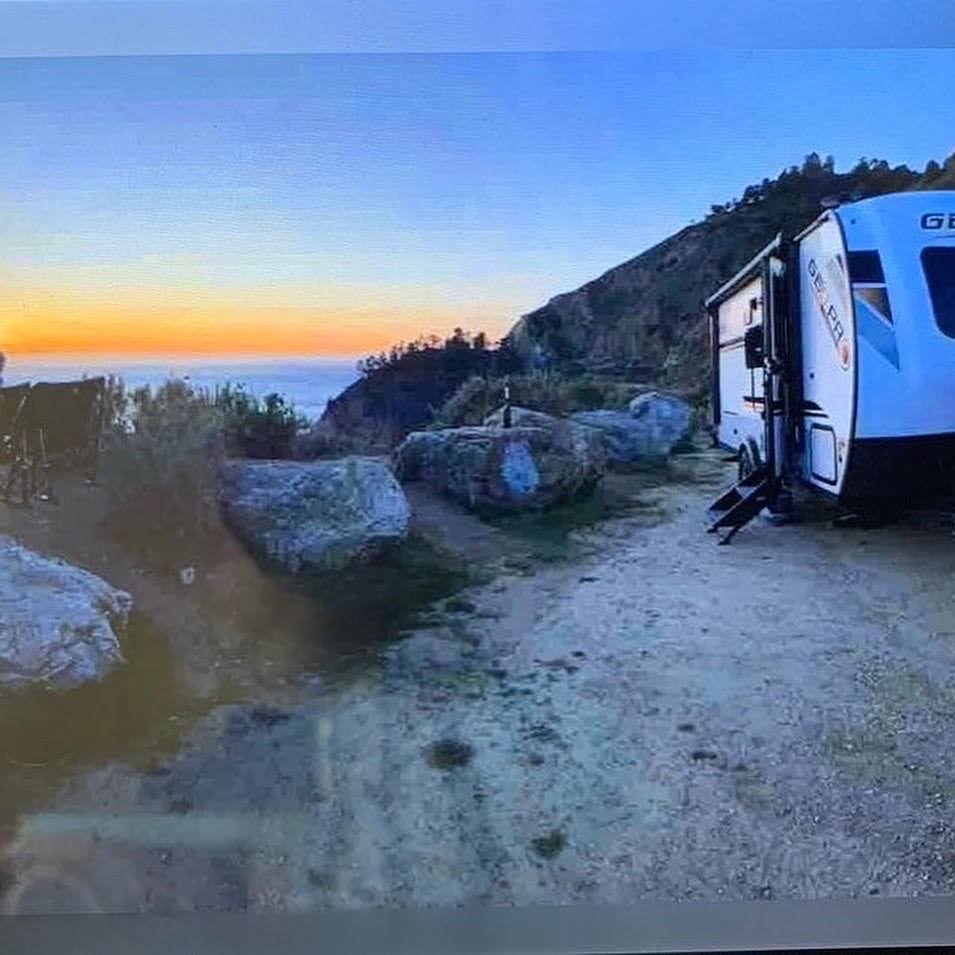 Camper parked near scenic ocean view.